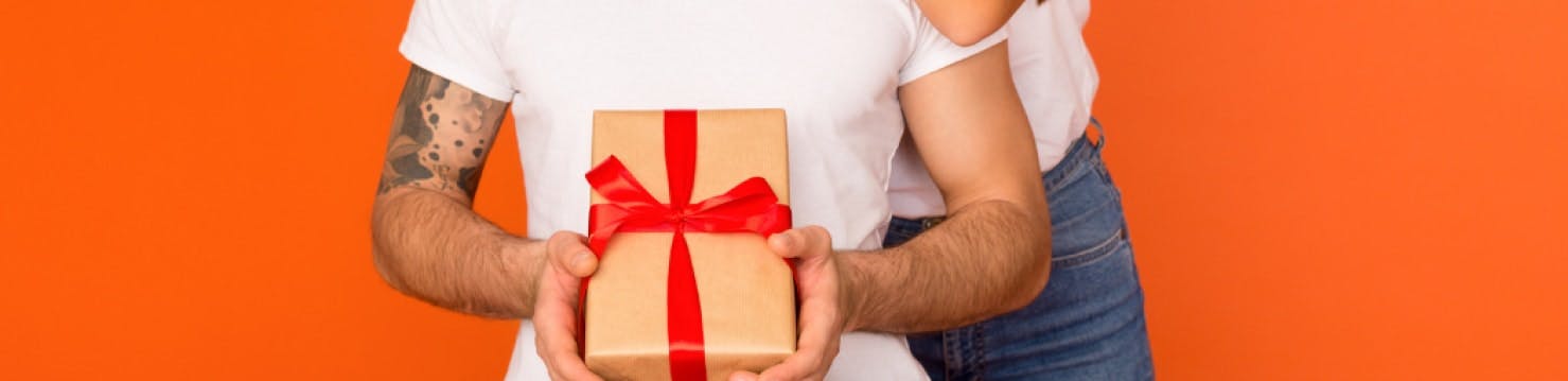 A man holding a wrapped gift.
